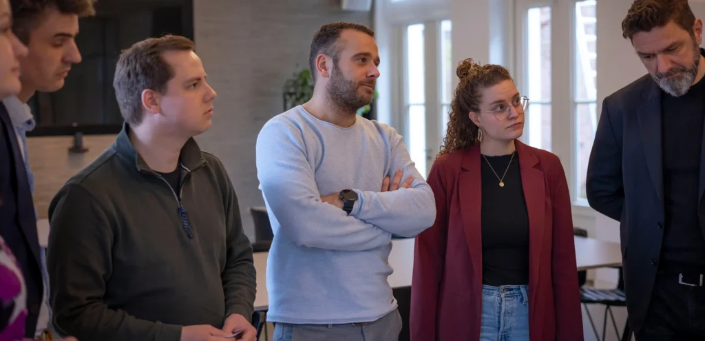 6 people standing and listening/paying attention